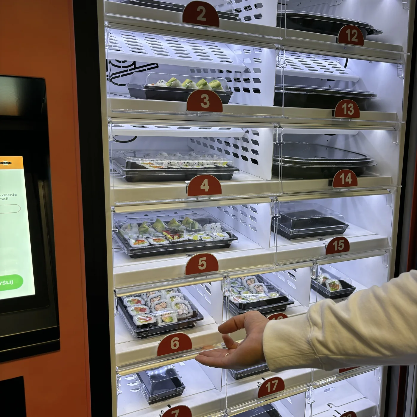Sušių rinkiniai maisto automato lentynose su numeruotomis spintelėmis