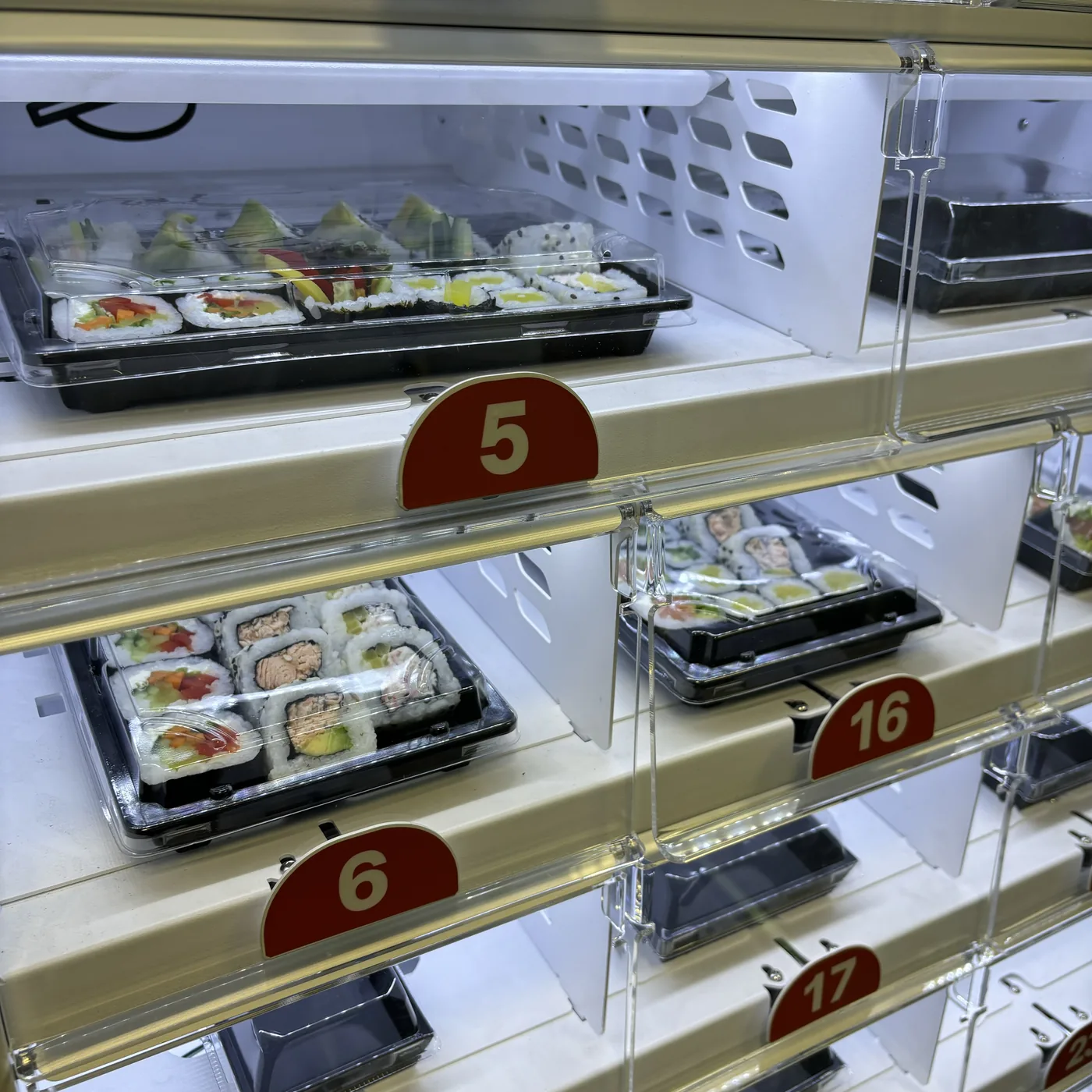 Sušių rinkiniai automato spintelėse iš arti – pakuotės su lazdelėmis