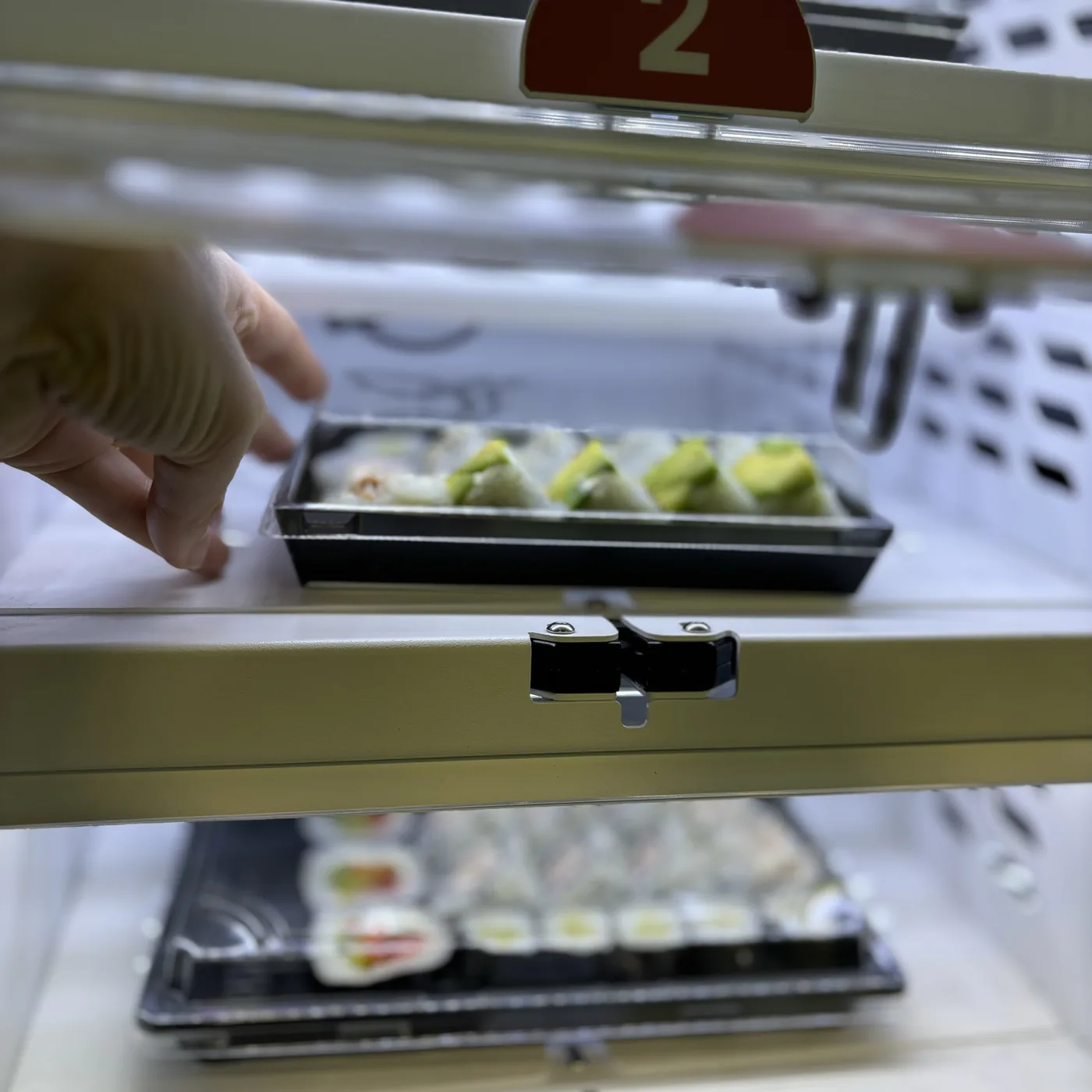 Atidaryta maisto automato spintelė su sušių pakuote
